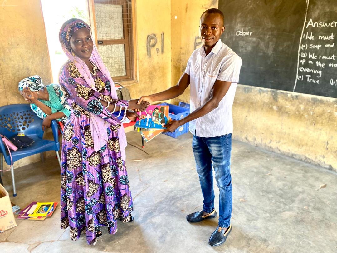 A class teacher receiving books on behalf of her students